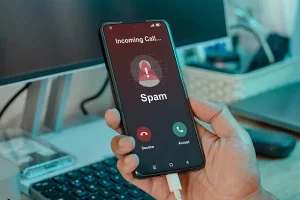 Smartphone showing an incoming call labeled Spam Likely