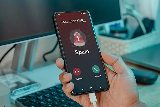 Smartphone showing an incoming call labeled Spam Likely